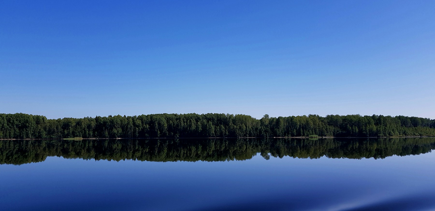 Helle Wasserfläche unter blauem Himmel als ruhiger visueller Ausgleich